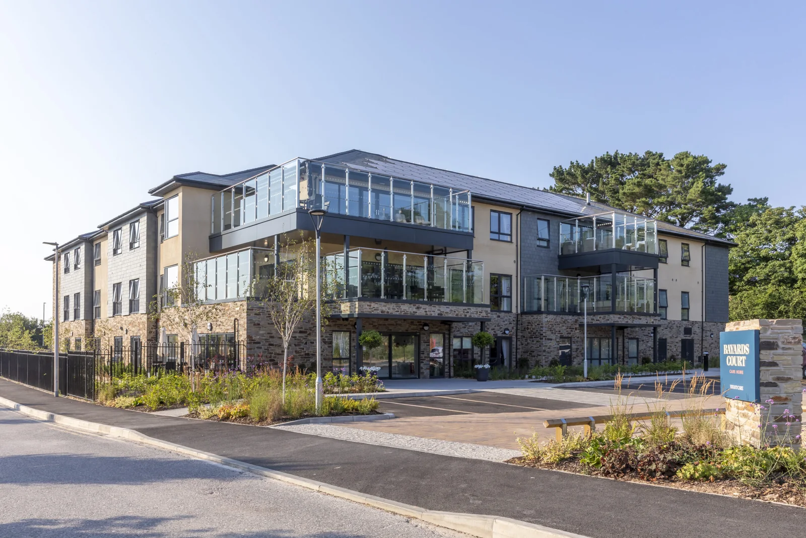 Bayards Court care home in Dartmouth from the road: three storeys of stone, render and slate with glazed balconies
