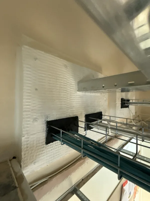 Batt seal panel with cable basket openings above a suspended ceiling