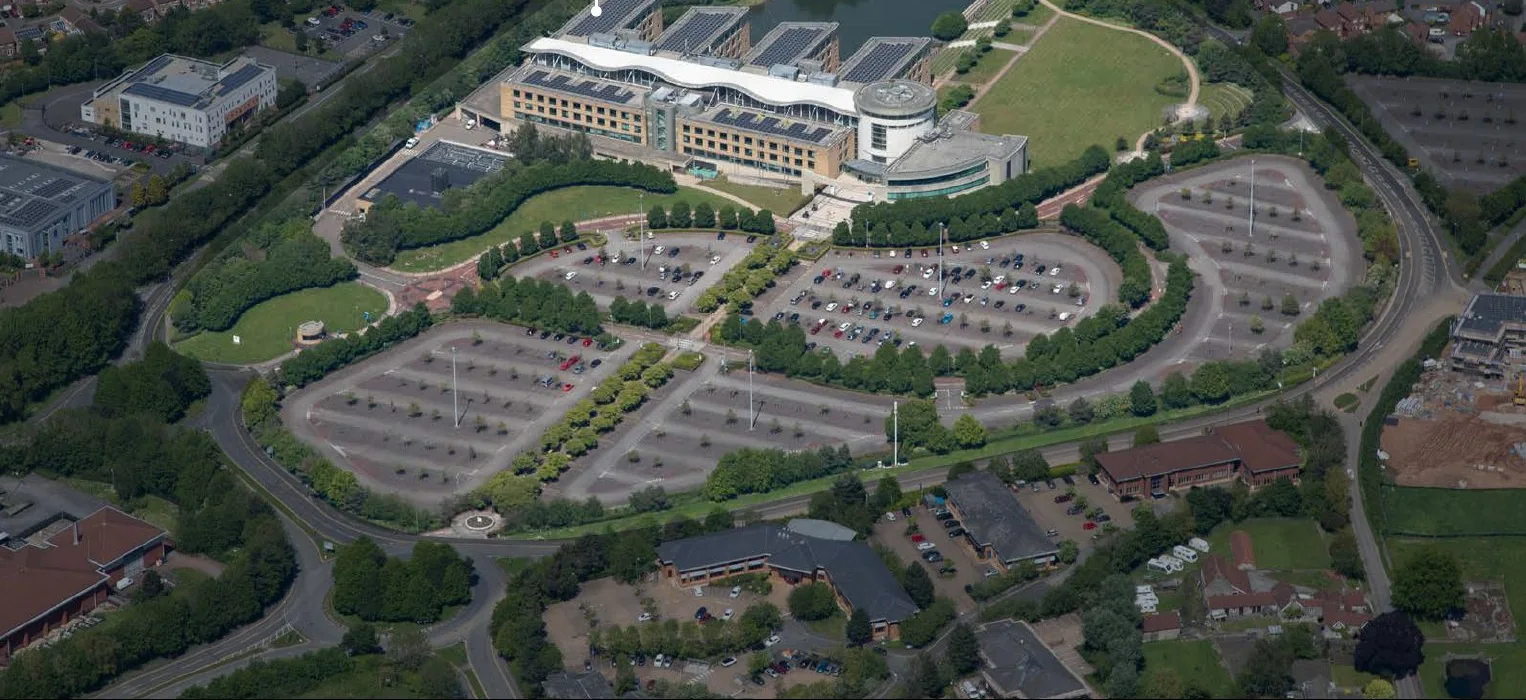 Aerial view of the Aviva Lake View office campus at Stoke Gifford, Bristol, with its curved roofs, lake and parkland